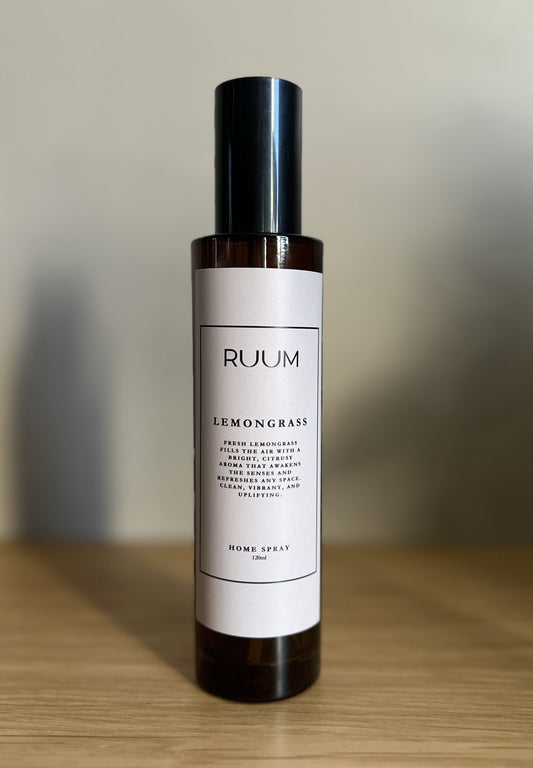 Bottle of Ruum Lemongrass home spray on a wooden surface with a blurred background